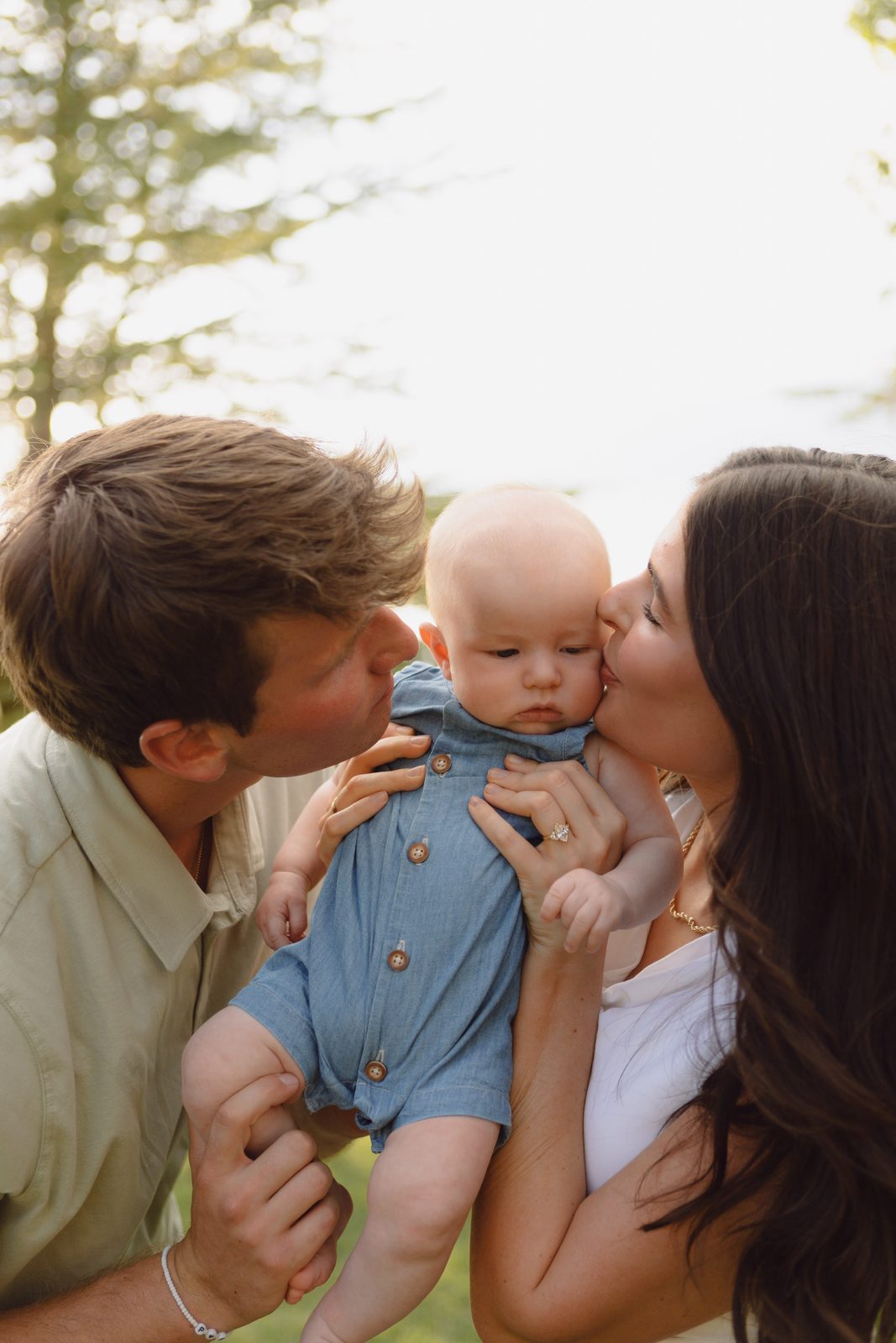 Parents kissing their baby, close family portrait