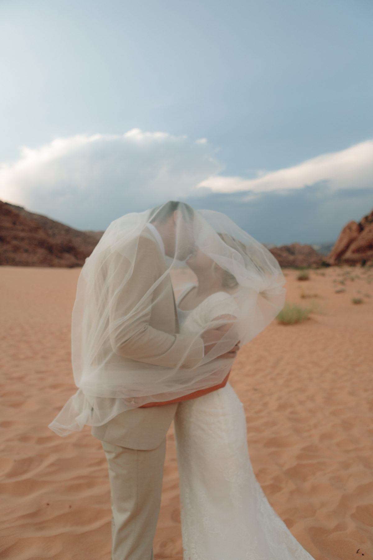 Bride's veil caught in the wind against red rock, black and white